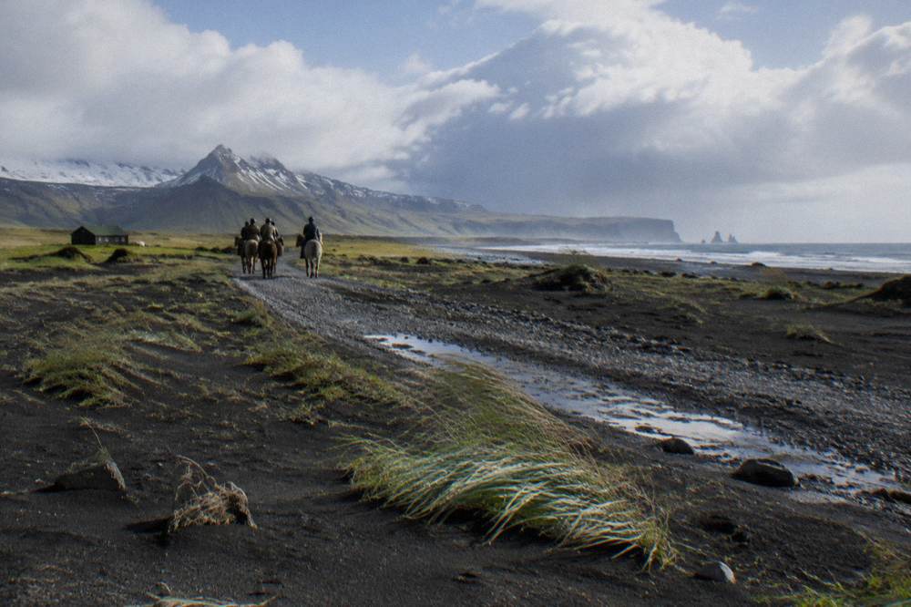 A gravel riding trail crossing a black sand landscape near the coast