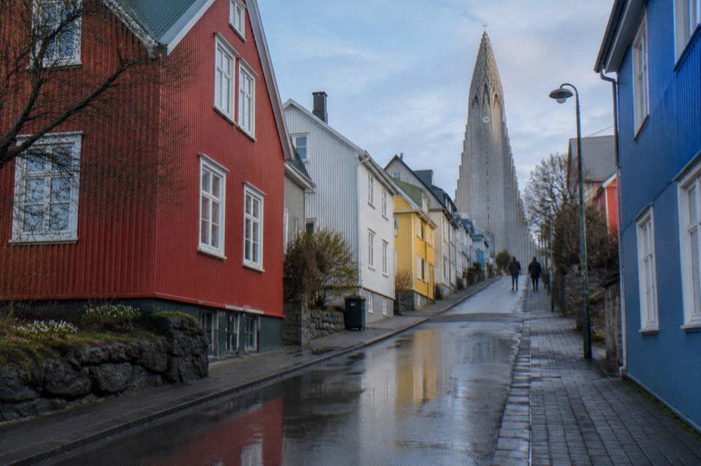 Colourful corrugated iron houses on a Reykjavik street with the Hallgrimskirkja tower rising behind them