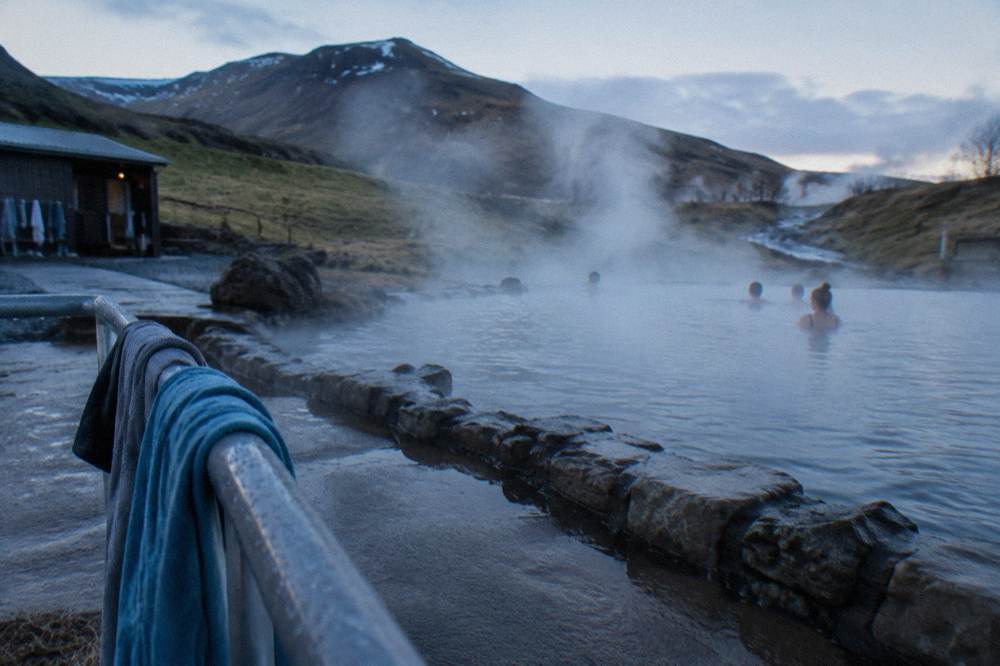 Steam rising from an outdoor geothermal pool in Reykjavik on a cool morning