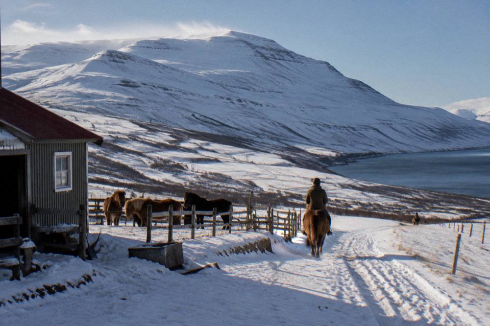 Snow-covered hills above a north Iceland valley with riding trails visible